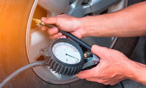 using a tire pressure gauge to check the air pressure